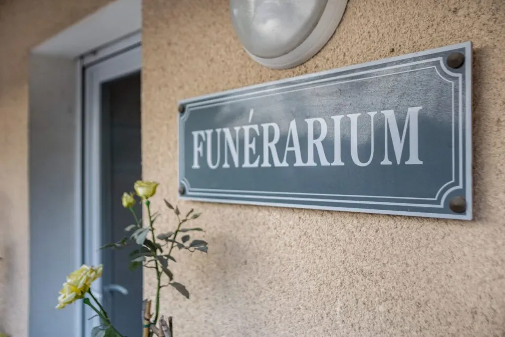 Gros plan sur la plaque signalétique « FUNÉRARIUM » posée sur la façade.